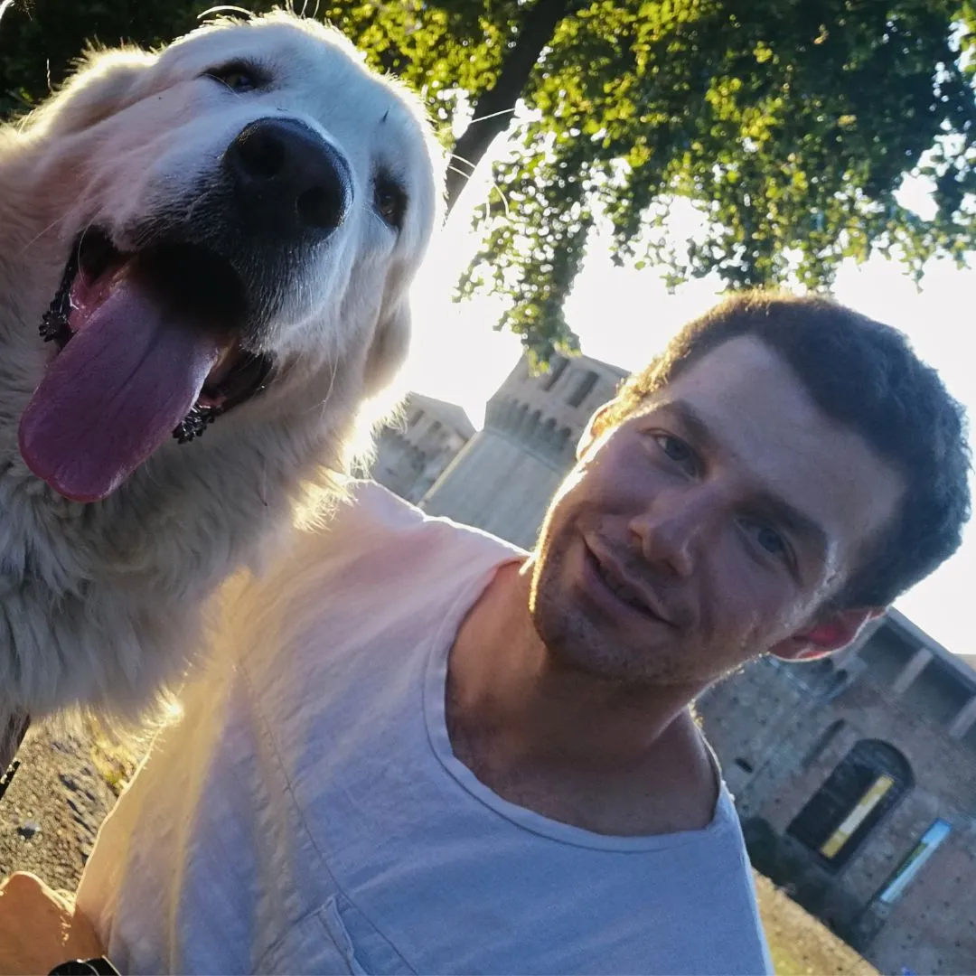 Guy near a black Labrador